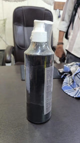 Black spray bottle with a white nozzle on a dark surface
